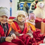 Drei Kinder schauen lachend in die Kamera
