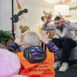 ein Mann liest in Gebärdensprache eine Gruppe von Kindern vor