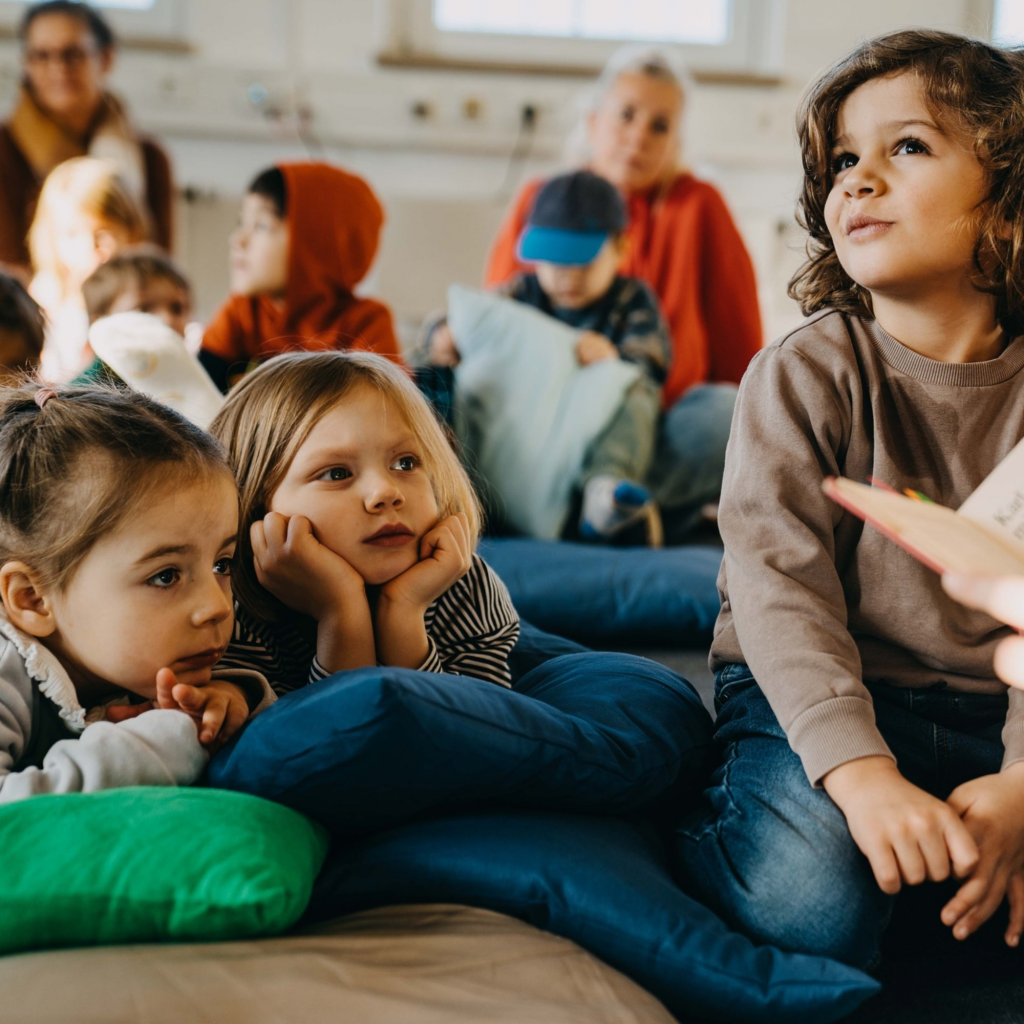 Eine Gruppe Kindern hört der Geschichte zu