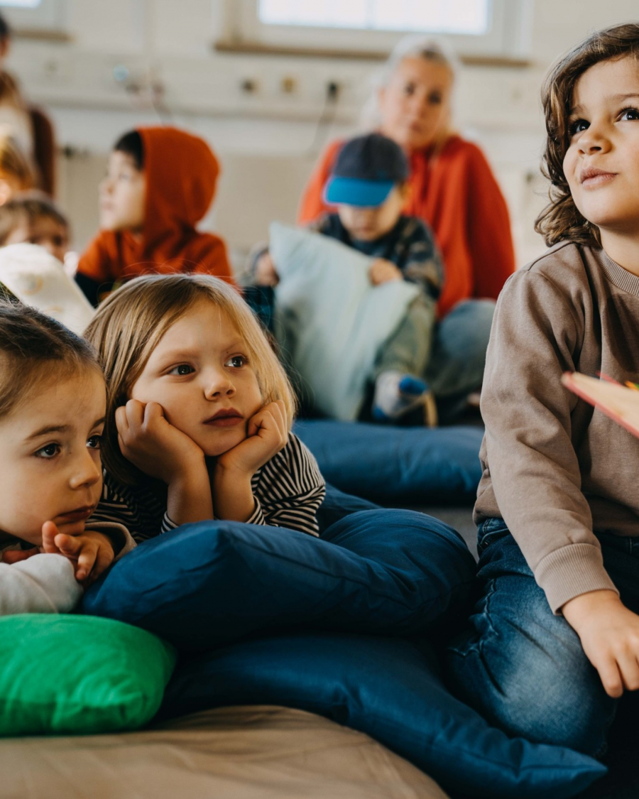 Eine Gruppe Kindern hört der Geschichte zu
